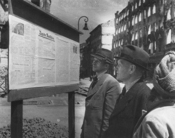 Readers stand in front of the 'Daily Rundschau' notice. The Daily Review was a newspaper published from May 15, 1945 to the end of June 1955 by the Red Army or Soviet Army in the Soviet Occupation Zone or the GDR. June 1946, Berlin, Germany