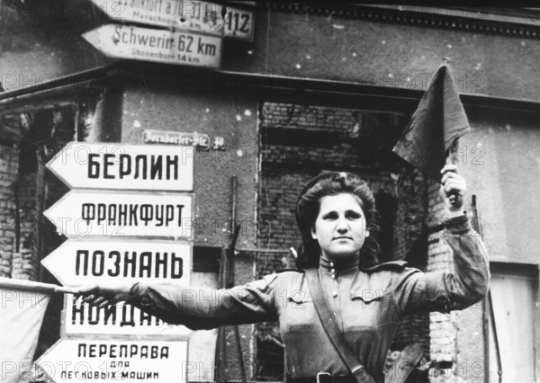 Russian traffic policewoman, Küstrin in April 1945, Germany J. Chaldej about this photo: I flew to Poznan (Posen) and from there I travelled on a tank to the German town of Küstrin on the Oder. The young woman who were in charge of the traffic had a difficult job. They were bombed, but were not allowed to leave their post at the ferry. Everyone ran and sought cover. But they had to stand still. Many of these woman lost their lives