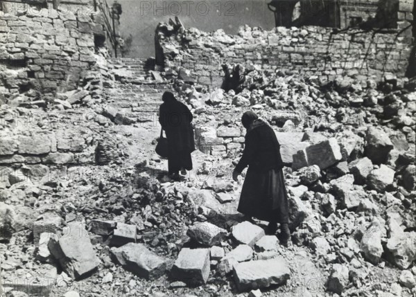 Two old woman in the rubble of a destroyed residential building, April 1945, Berlin