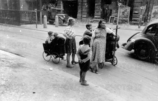 Civilians, two woman and their children with trolleys, Berlin at the beginning of May 1945, Germany