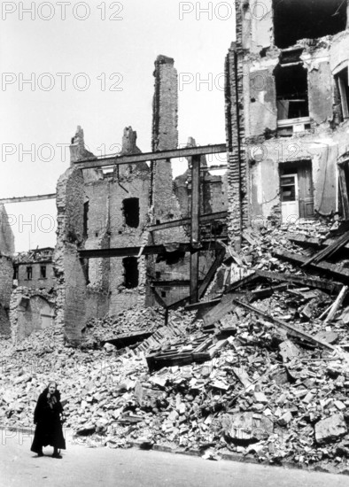 Civilians, an old woman in front of the rubble of a residential building, Berlin April 1945, Germany