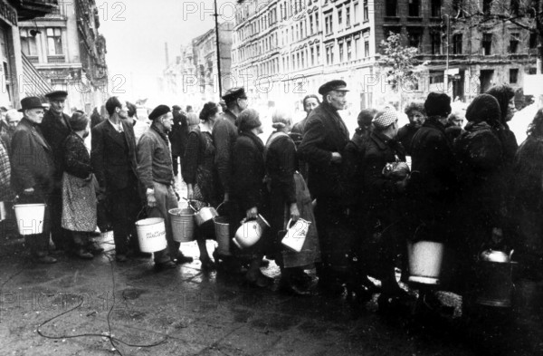 Supplying the population after surrender, civilians waiting in line to fetch water, Berlin May 1945, Germany