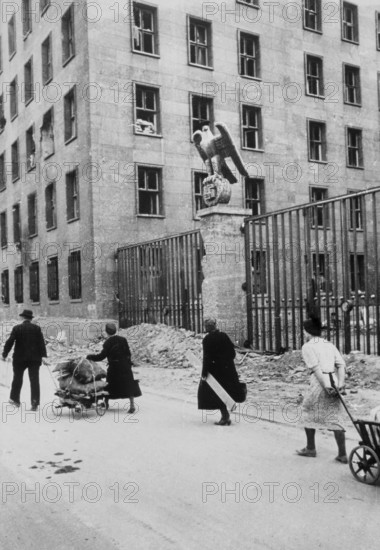 Civilians walk with their belongings in front of the Reich Ministry of Aviation in Wilhelmsstraße, Mitte, Berlin April 1945