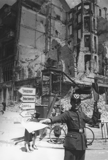 Traffic police officer in front of a destroyed residential building, Berlin June 1945, Germany