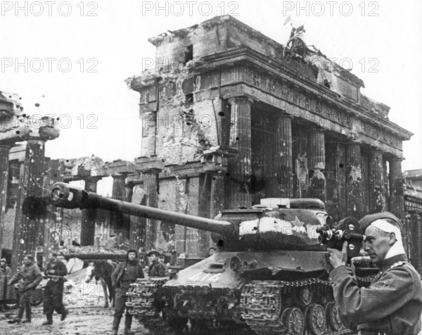 Injured Soviet soldier with film camera in front of the Brandenburg Gate, May 1, 1945, Berlin, Germany