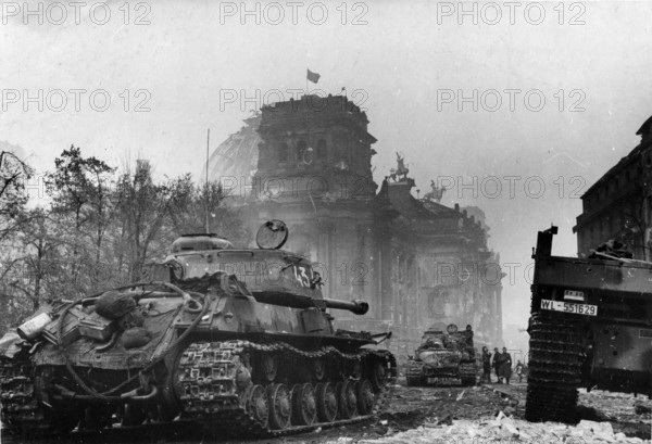 View of the Reichstag on May 1, 1945 with the Soviet flag on the roof. View from the Brandenburg Gate. Soviet IS-2 tank in the foreground. Photo by Victor Tjomin. Berlin, Germany
