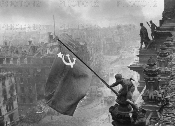 Auf dem Berliner Reichstag, 2. Mai 1945, drei sowjetische Soldaten hissen die Flagge der Sowjetunion. Bei den drei Soldaten handelt es sich den Ukrainer Alexei Leontjewitsch Kowaljow, den Kumyken Abdulchakim Issakowitsch Ismailow und den Weißrussen Leonid Goritschew. J. Chaldej machte 36 Aufnahmen, die er später auch veränderte. Das Bild wurde zur Ikone und zum Symbol für den Sieg über den Nationalsozialismus. Variante mit zwei Uhren, Rauch Retusche