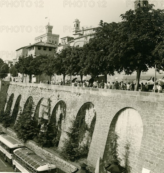 Historic city wall with tourists and historic buses, photo taken in summer 1961, San Marino, Italy