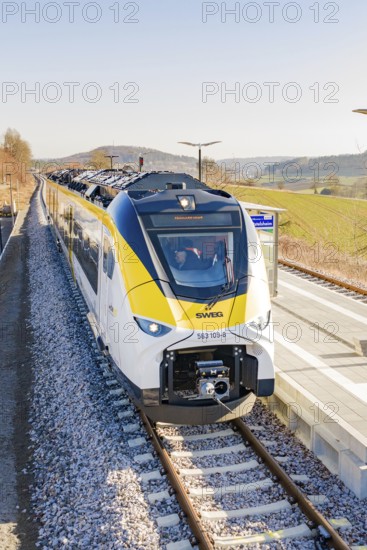 Front view of a modern train at the station, surrounded by hilly landscape, test run on the new Hermann-Hesse railway with Siemens Mireo Plus B trains, Calw, Germany