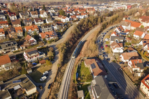 Aerial view of a city with red roofs and a train on rails, test run on the new Hermann-Hesse railway with Siemens Mireo Plus B trains, Calw, Germany