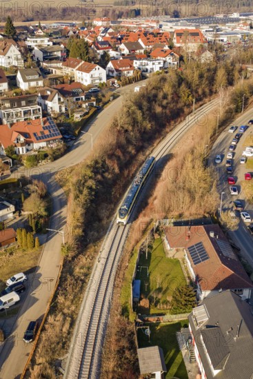 Aerial view of a railway line running through a town with red roofs and surrounding nature, test run on the new Hermann Hesse railway with Siemens Mireo Plus B trains, Calw, Germany