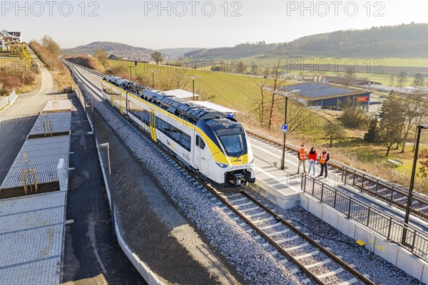 Train on the platform, landscape with hilly surroundings and people on the track, test run on the new Hermann Hesse railway with Siemens Mireo Plus B trains, Calw, Germany