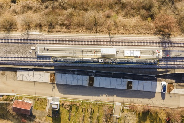 Aerial view of a train station with train tracks surrounded by trees and vegetation, test run on the new Hermann-Hesse railway with Siemens Mireo Plus B trains, Calw, Germany