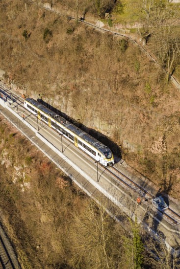 Aerial view of a train traveling through a wooded area surrounded by bare trees, test run on the new Hermann-Hesse railway with Siemens Mireo Plus B trains, Calw, Germany