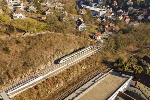 Overview of a train in a village with numerous houses and autumn landscape, test run on the new Hermann-Hesse railway with Siemens Mireo Plus B trains, Calw, Germany