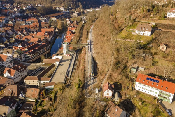 Train route through hilly village with red roofs and a river, test trip on the new Hermann-Hesse railway with Siemens Mireo Plus B trains, Calw, Germany