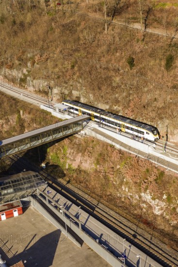 A train crosses a bridge surrounded by bare autumn trees and railroad tracks, test run on the new Hermann Hesse Railway with Siemens Mireo Plus B trains, Calw, Germany