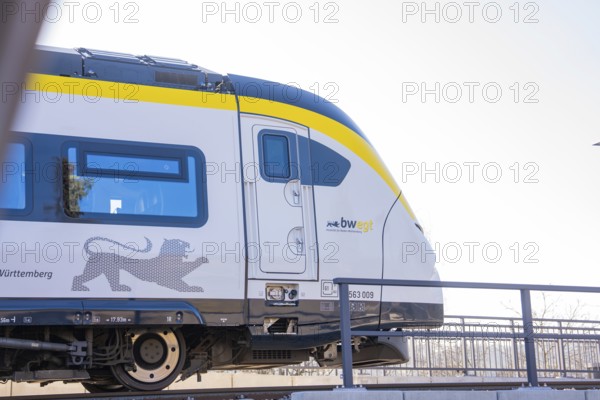 Modern yellow and white train on tracks in sunny surroundings, test run on the new Hermann-Hesse railway with Siemens Mireo Plus B trains, Calw, Germany