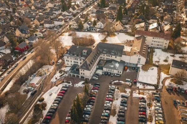 View of a large building complex with parking spaces and surrounding residential area in winter, District Office, Freudenstadt, Black Forest, Germany