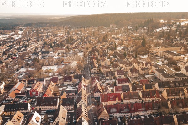 Panoramic view of a city in sunlight with numerous roofs and adjacent forest, Freudenstadt, Black Forest, Germany