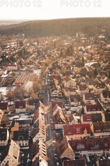 Aerial view of a city with red roofs surrounded by forests and light snow, Freudenstadt, Black Forest, Germany