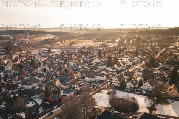 Aerial view of residential area at sunset, snow-covered landscape and rooftops, Freudenstadt, Black Forest, Germany
