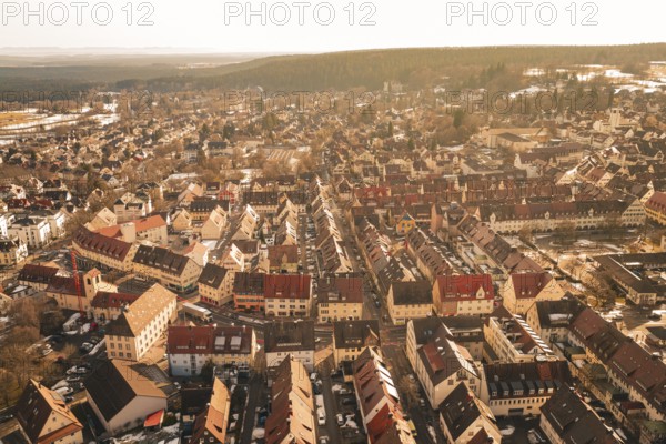 Aerial view of a winter town with rustic houses and snow-covered streets in warm lighting, Freudenstadt, Black Forest, Germany