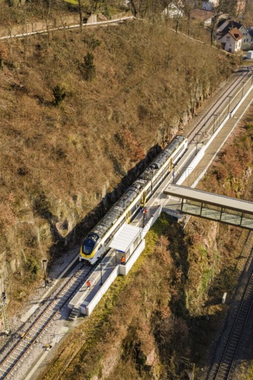Vertical view of a train station with bridge surrounded by autumn landscape, test run on the new Hermann-Hesse railway with Siemens Mireo Plus B trains, Calw, Germany