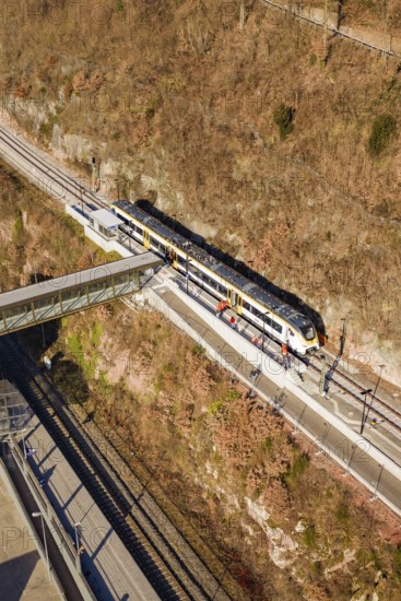 Train travels through hilly landscape over bridge surrounded by vegetation and tracks, test run on the new Hermann Hesse railway with Siemens Mireo Plus B trains, Calw, Germany