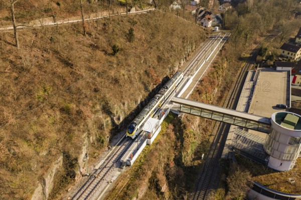 Aerial view of a train station with a train in hilly landscape and autumn colors, test run on the new Hermann Hesse railway with Siemens Mireo Plus B trains, Calw, Germany