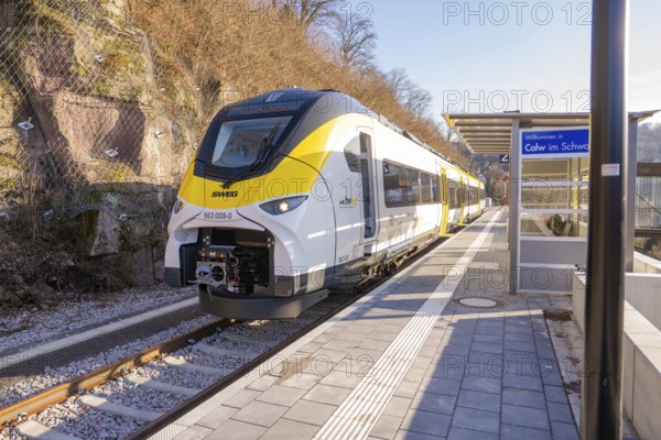 Modern train at a small train station surrounded by trees and hills, test run on the new Hermann-Hesse railway with Siemens Mireo Plus B trains, Calw, Germany