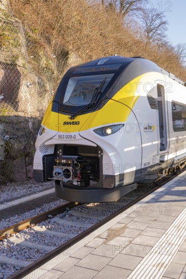 Yellow-black train at a small train station in a mountainous landscape, test run on the new Hermann-Hesse railway with Siemens Mireo Plus B trains, Calw, Germany