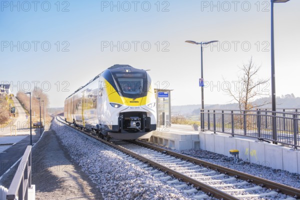 Modern train on the track in front of a small train station in sunshine, test run on the new Hermann-Hesse railway with Siemens Mireo Plus B trains, Calw, Germany
