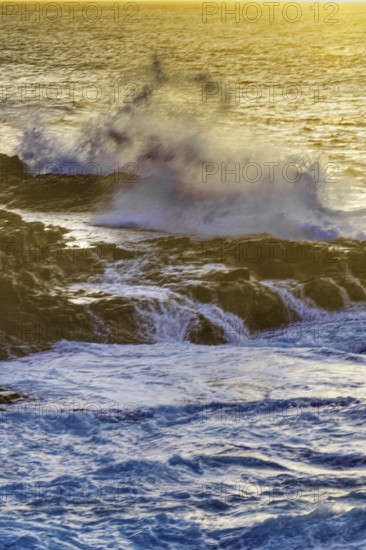 High waves hit hard against rocks in the light of a brilliant sunset, Playa Blanca/Yaiza Lanzarote
