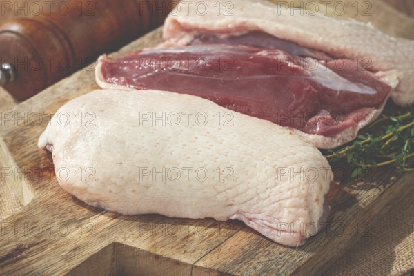 Fresh raw duck breast, on a wooden chopping board, top view, no people