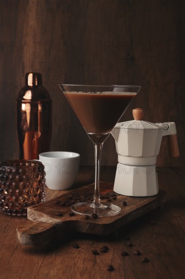Espresso martini cocktail, alcoholic drink, shaker and geyser coffee maker, on a wooden background