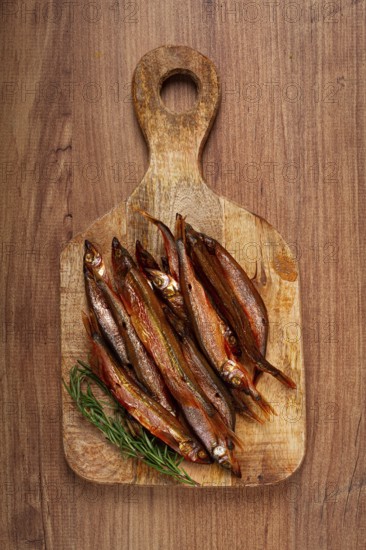 Cold smoked capelin, on a wooden chopping board, no people