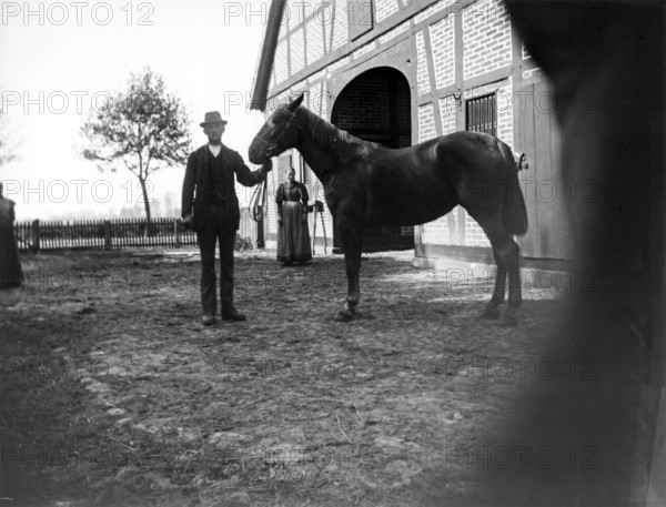 Man with horse posing for the photo, woman, farm, ca. 1920-1930, retro, vintage, old, historic, northern Germany