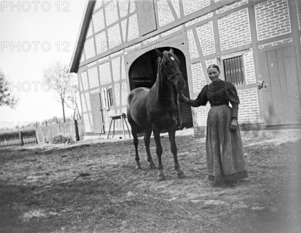 Woman with horse posing for the photo, farm, ca. 1920-1930, retro, vintage, old, historic, northern Germany