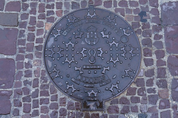 Manhole cover with the coat of arms of the city of Krakow, Krakow, Poland