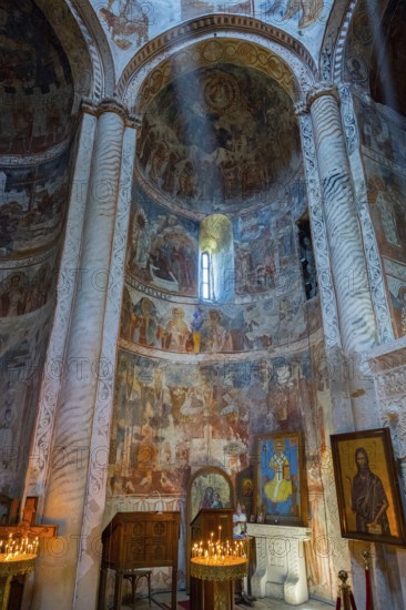 Church interior with frescoes and columns illuminated by a mystical ray of light, Nikorzminda Cathedral, Racha-Lechkhumi region, Lower Svaneti, Georgia