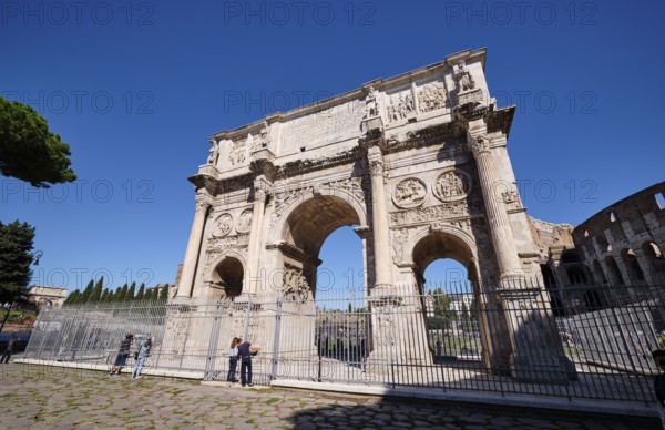Arch of Constantine with detailed reliefs under blue sky, Rome, Lazio, Italy