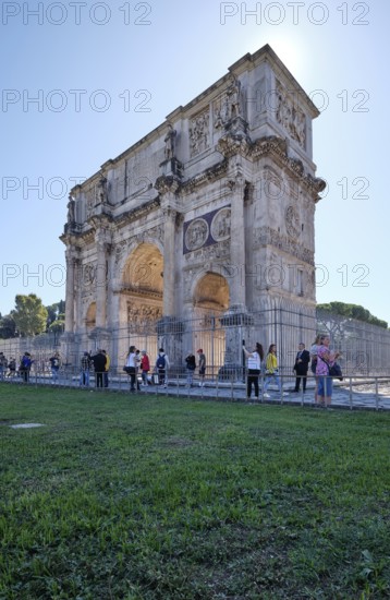 Arch of Constantine with detailed reliefs surrounded by tourists, Rome, Lazio, Italy