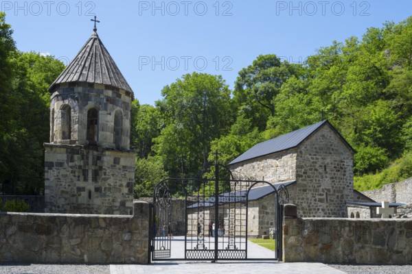 Stone church in a forest under a blue sky with an entrance gate, Chitakhevi Church of St. George, The Green Monastery, Mtsvane Monastery, Samtskhe-Javakheti Region, Samtskhe-Javakheti, Georgia
