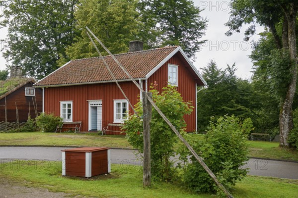 Red wooden house with green garden and trees, Linnés Råshult, Älmhult, Kronobergs län, Småland, Sweden