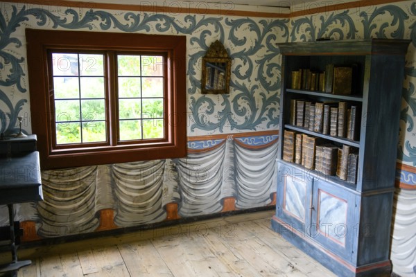 Small room with an antique bookshelf and artfully decorated walls next to a window in the birthplace of botanist and founder of the binary nomenclature Carl von Linné, Linnés Råshult, Älmhult, Kronobergs län, Småland, Sweden