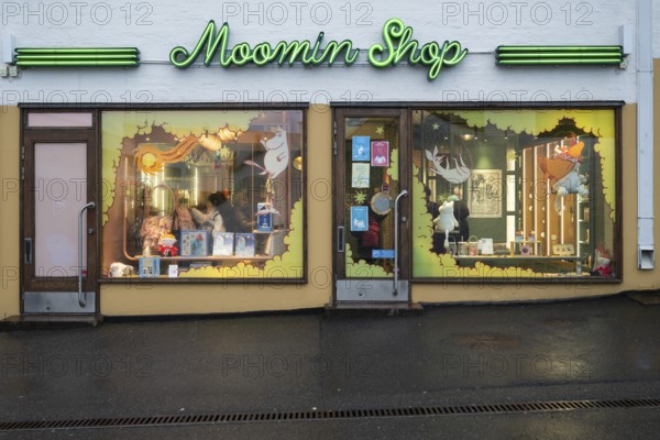 Illuminated shop window, shop in the city center selling merchandise and products related to the Moomin or Moomin book series by Finnish children's book author and illustrator Tove Jansson, Helsinki, Finland