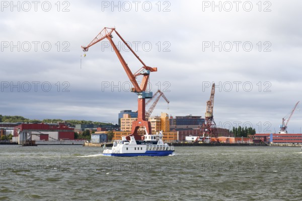 Large industrial port crane and ship on water under cloudy sky in Gothenburg harbour, Gothenburg, Västra Götalands län, Sweden