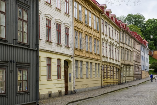 A series of colorful old buildings with decorated facades along a cobblestone street in the Haga district of Gothenburg, Västra Götalands län, Sweden