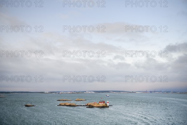 Wide sea with small rocky island under cloudy sky, Gothenburg, Västra Götalands län, Sweden